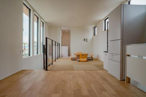 a hallway with a table in a room with windows at オーシャンヴィラ館山 in Tateyama