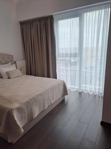 una camera da letto con un letto e una grande finestra di JBHotels Apartament Deluxe Hanza Tower a Stettino
