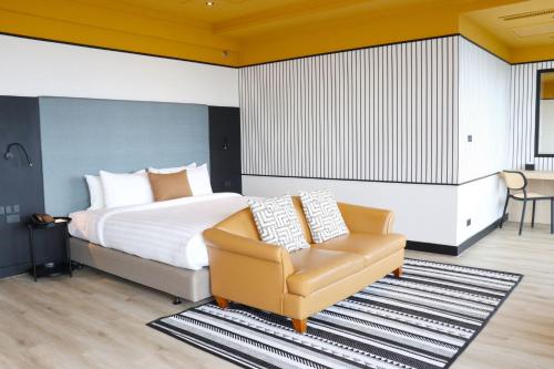 a bedroom with a bed and a chair at The Quarter Saphankhwai by UHG in Bangkok