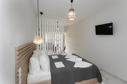 Un dormitorio con una cama con almohadas blancas. en Ella apartments, en Parga