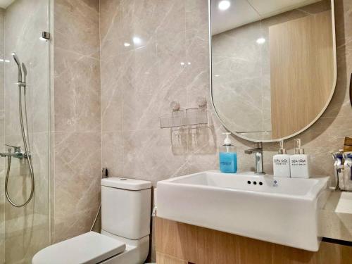 a bathroom with a sink and a toilet and a mirror at Căn hộ 1PN VIEW HỒ BƠI CAO CẤP, FREE POOL, GYM in Gò Công