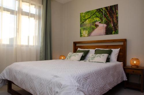 una camera da letto con un grande letto bianco con due cuscini di Ellara Escapes - Modern 1-Bedroom Apartment with Hill View - Sodnac, Quatre Bornes a Quatre Bornes