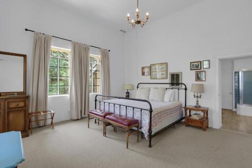 a bedroom with a bed and a chair and a chandelier at Live Oak Ranch in Spring Branch