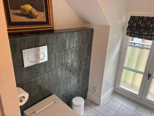 a bathroom with a green tiled wall at Manoir Des Douets Fleuris in Cancale