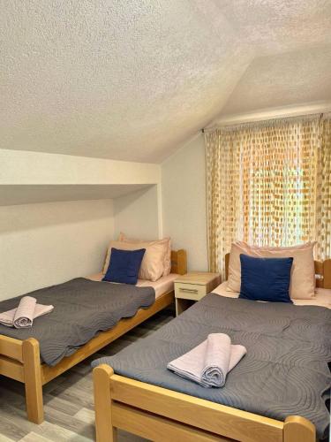 a bedroom with two beds with blue pillows at Apartments Slavica in Ohrid