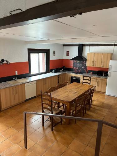 a large kitchen with a wooden table and chairs at Gîte Le Grand Chêne 