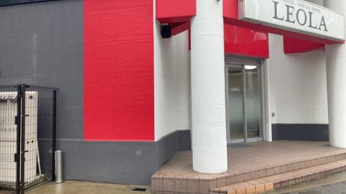 a red and white facade of a building with a door at HOTEL LEOLA - Vacation STAY 25772v in Osaka
