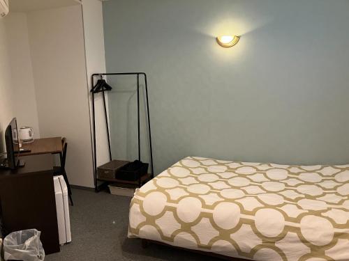 a bedroom with a bed and a light on the wall at HOTEL LEOLA - Vacation STAY 25772v in Osaka
