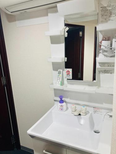 a bathroom with a white sink and a mirror at HOTEL LEOLA - Vacation STAY 25772v in Osaka