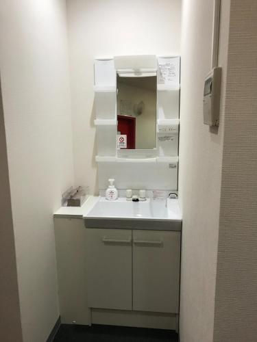 a bathroom with a white sink and a mirror at HOTEL LEOLA - Vacation STAY 25772v in Osaka