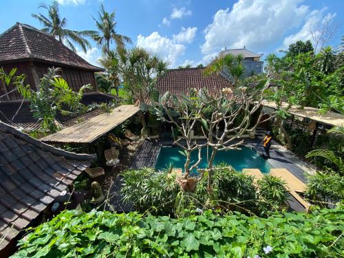 ウブドにあるNingmas Garden By Sidhi Hospitality Experiencesのスイミングプール付きの庭園の空中ビュー