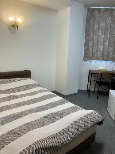 a bedroom with a bed and a table and a window at HOTEL LEOLA - Vacation STAY 25772v in Osaka