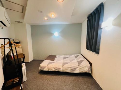 a small bedroom with a bed and a window at HOTEL LEOLA - Vacation STAY 25772v in Osaka