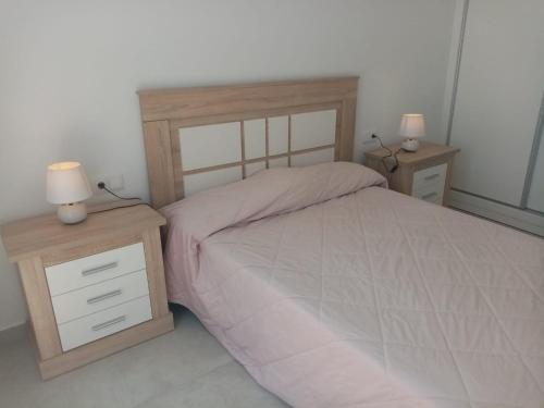 a bedroom with a bed with two night stands and two lamps at Villa San Benito in Los Montesinos