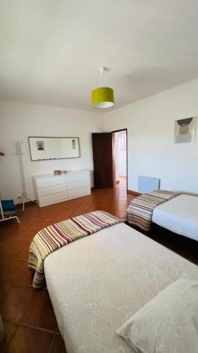 a living room with two beds and a floor at Quinta dos Moledros in Figueira