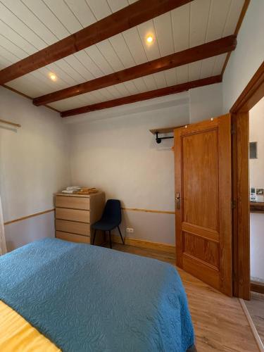 a bedroom with a blue bed and a wooden cabinet at A Casa Amarela Guesthouse in São Martinho da Cortiça