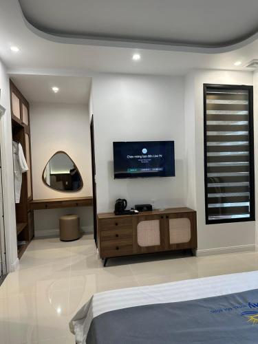 a bedroom with a bed and a tv on the wall at Sunny Hotel in Ðố Sơn