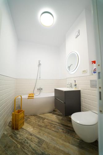 a bathroom with a toilet and a sink and a tub at CristAlex Sunset in Constanţa