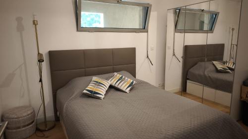 une chambre avec un lit avec deux oreillers dessus dans l'établissement Appartement T2 neuf avec piscine à Sainte-Maxime, à Sainte-Maxime