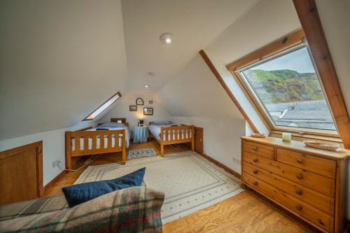 Camera mansardata con letto e finestra. di Fisherman's Cottage in Pennan a Pennan