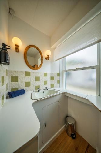 a bathroom with a sink and a mirror at Fisherman's Cottage in Pennan in Pennan