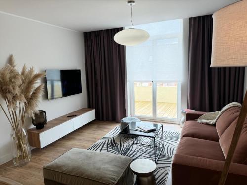 a living room with a couch and a tv at Hélios Plage in Berck-sur-Mer