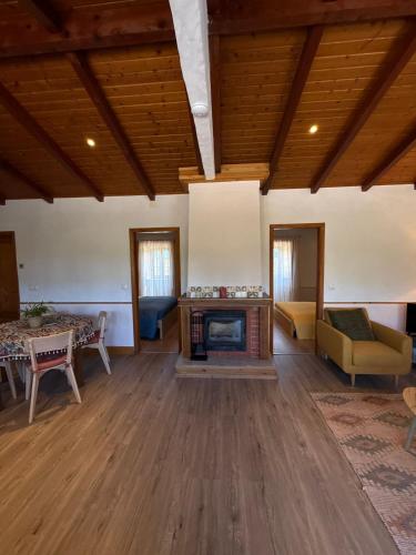 a large living room with a fireplace and wooden ceilings at A Casa Amarela Guesthouse in São Martinho da Cortiça