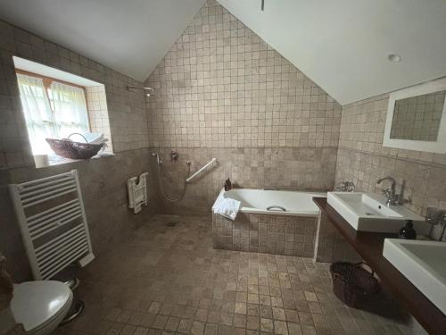 a bathroom with a tub and a sink and a toilet at Manoir Des Douets Fleuris in Cancale