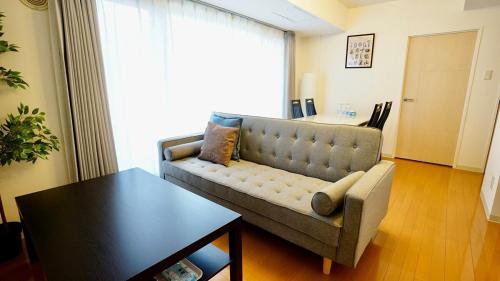 a living room with a couch and a table at Helios Nakajima Park 907 Susukino Sapporo in Sapporo