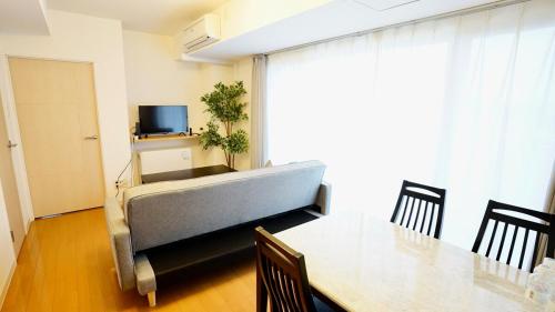 a living room with a table and a couch at Helios Nakajima Park 907 Susukino Sapporo in Sapporo