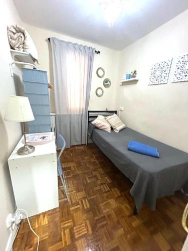 a small room with a bed and a window at Habitaciones en Luisa in Madrid