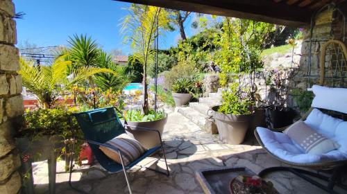 a patio with chairs and potted plants at Mas des Buscades in Cabris