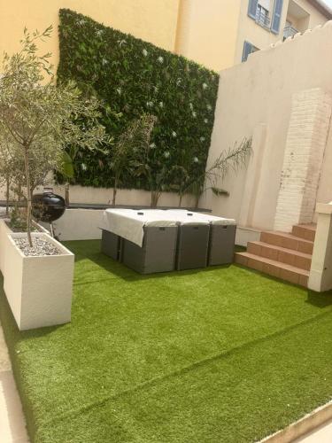 un petit jardin avec un lit d'herbe verte dans l'établissement Appartement Duplex Bord de Mer, à Cagnes-sur-Mer