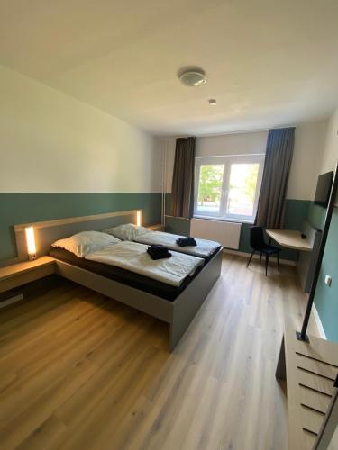 a bedroom with a bed and a desk and a window at A2rooms in Lehnin
