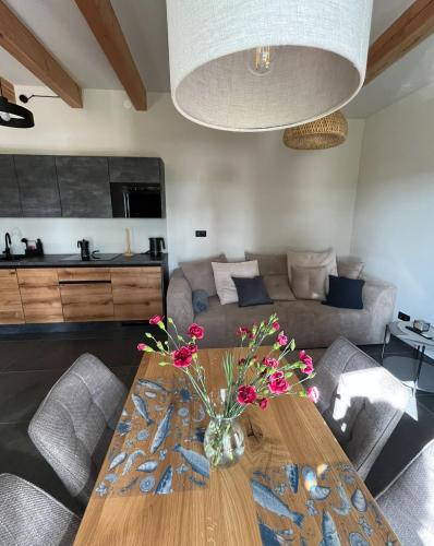- un salon avec une table en bois et des fleurs dans l'établissement Dom w Brzozach, à Rowy