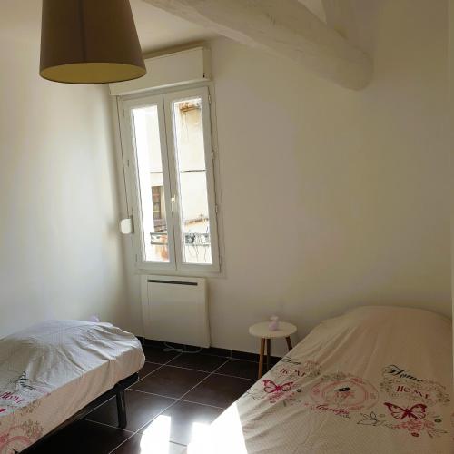 une chambre avec un lit et une fenêtre dans l'établissement Chez Francis, Avignon Centre, à Avignon