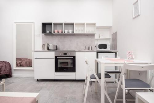a white kitchen with a table and a stove at Maja's Sweet Little Home with Free Parking and Air Condition in Budapest