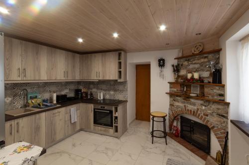 cocina con chimenea de piedra y fogones en Ouranias house, en Kokkari