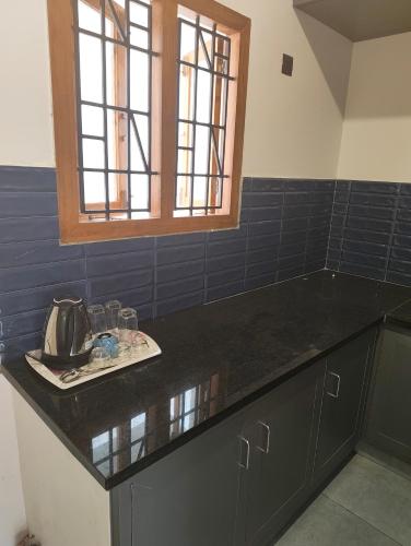 a kitchen with a black counter top and a window at One4ALL SALVIA in Chennai