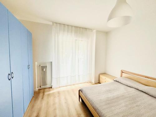 a bedroom with a bed and a large window at Maredena - Comodo al centro e al Mare - Immobil Relax in Lido di Jesolo