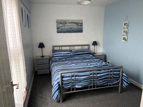 a bedroom with a bed with a blue and white comforter at 39 Perran View Your Home Away from Home in Cornwall in St. Agnes