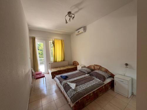 a bedroom with a bed and a couch in it at Klassz Apartmanház in Balatonfüred
