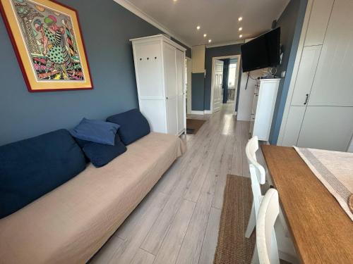 a living room with a couch and a kitchen at Apartament Heljan, 150 m od plaży in Gdańsk