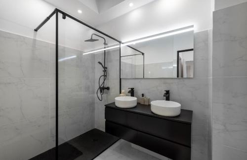 une salle de bain avec deux lavabos et une douche en verre dans l'établissement apartment in Cannes-Croisette, à Cannes