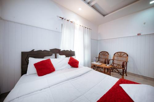 a bedroom with a large white bed with red pillows at Munroe Island Lake Resort in Kollam