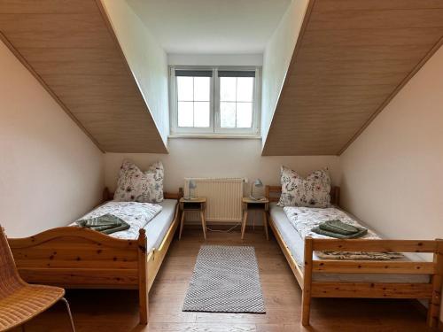 a attic room with two beds and a table at Ferienwohnung Zur Ochsenweid in Furth im Wald