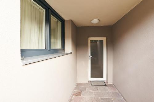 a hallway with a window and a glass door at Pension Sunnhofer in Vilpiano