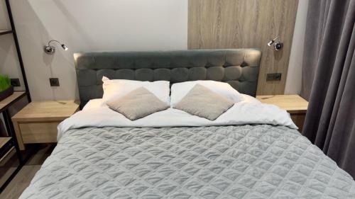 Un dormitorio con una cama grande con dos almohadas. en HERMES Cityview Apartment, en Chişinău