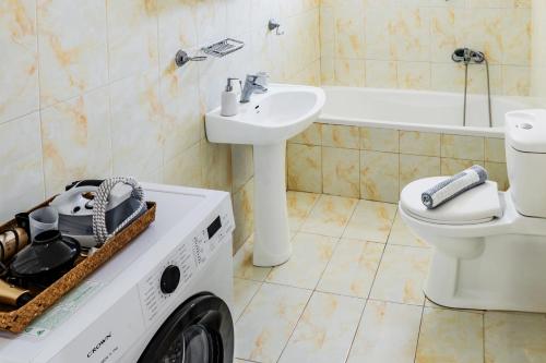 - un lave-linge dans la salle de bains pourvue d'un lavabo et de toilettes dans l'établissement Ruby house Preveza, à Prévéza
