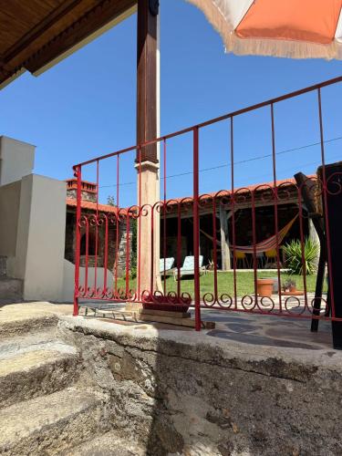 a fence in front of a building with a playground at A Casa Amarela Guest room in São Martinho da Cortiça